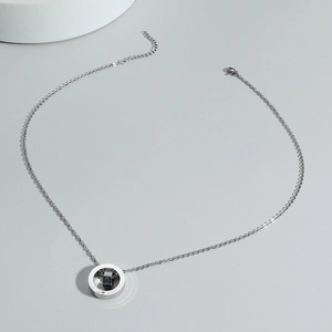 Double ring letter necklace with silver and black nested rings on a delicate steel chain