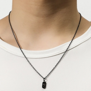 Gros plan du pendentif carré noir avec le chiffre 7 argenté sur une chaîne noire