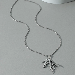 Collier avec pendentif double feuille d'érable au fini argenté vieilli sur fond gris