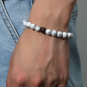 Retro white turquoise and tiger eye beaded bracelet on a wrist against denim background