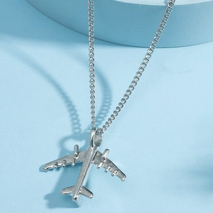 Detailed close-up of a silver airplane pendant necklace with a fine cross-link chain