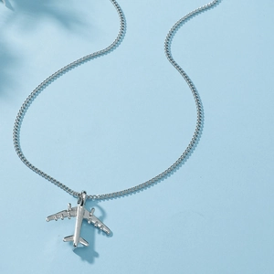 Detailed close-up of a silver airplane pendant on a slim O-chain necklace