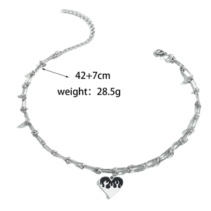 Détail du pendentif cœur à motif de flamme noire avec chaîne à maillons réglable