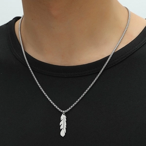 Close-up of realistic silver feather pendant necklace on stainless steel box chain