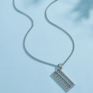Collier avec pendentif boulier en argent rétro et perles métalliques sur fond bleu