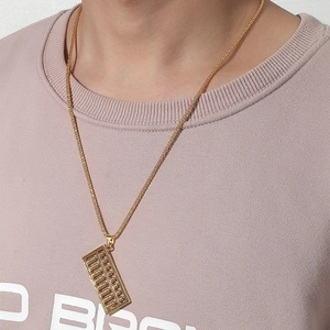 Gros plan détaillé du collier avec pendentif boulier doré porté sur un t-shirt lavande