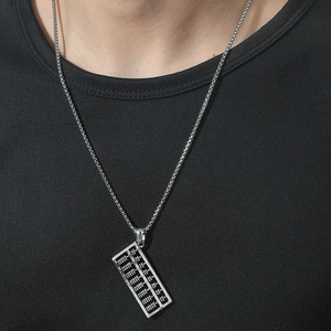 Gros plan d'un collier pendentif boulier en argent sur un t-shirt noir pour hommes