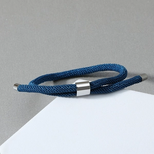 Gros plan d'un bracelet nautique en corde tressée bleu marine avec boucle en métal poli