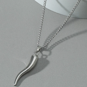 Pendentif cornicello corne italienne en acier inoxydable poli sur fond gris minimaliste