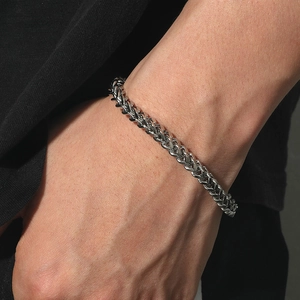Men's titanium steel spiga wheat chain bracelet on wrist in a stylish silver finish