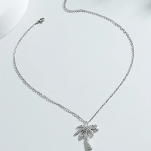 Minimalist silver palm tree pendant necklace with sparkling crystals on a fine chain