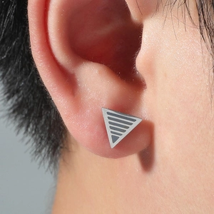 Polished stainless steel triangle stud earring with grey stripes on male model ear