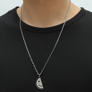 Cute cartoon smiley pendant necklace in stainless steel worn by a male model