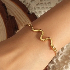 Minimalistisches goldenes Schlangenarmband mit poliertem Wellendesign für einen modernen Look