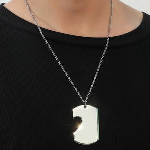 Polished stainless steel heart puzzle pendant necklace on black ribbed fabric background