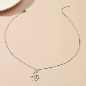 Collana minimalista in argento con pendente madre e figlio su uno sfondo beige caldo