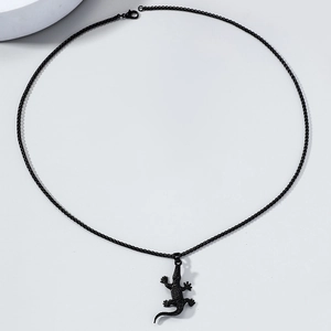 Gros plan du pendentif lézard punk noir avec texture mate et chaîne à billes noire