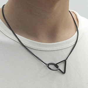Vue macro du collier en titane noir mat avec pendentif géométrique anneau et triangle