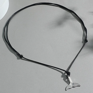 Adjustable whale tail pendant necklace with black cord on a textured gray background
