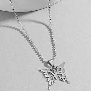 Pendentif papillon évidé en acier inoxydable sur chaîne à billes sur fond gris