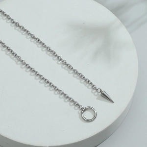 Minimalistische geometrische Kette mit Silberkegel-Anhänger auf weißem Marmorstein