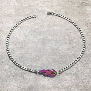 Vue macro du pendentif flamme irisé sur une chaîne gourmette en argent avec fermoir