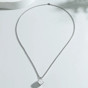 Close-up of minimalist stainless steel necklace with a unique silver dice pendant design