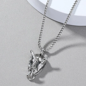 Détail du pendentif rhinocéros rétro avec chaîne à mailles sur un décor en pierre