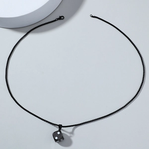 Detailed macro view of black minimalist dice pendant on fine metal chain necklace
