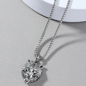 Gros plan d'un pendentif tête d'ours en argent vintage avec une chaîne à mailles