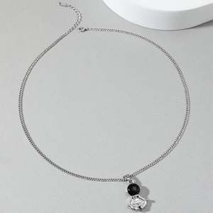 Silver astronaut pendant necklace with black stone helmet on minimalist display base