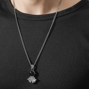 Hip hop style silver astronaut pendant necklace with black visor worn on black tee