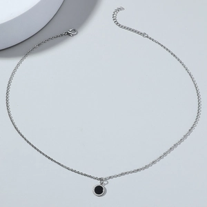 Close-up of silver O-chain necklace with black round pendant and Roman numeral edge