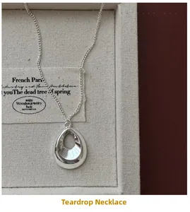 Gros plan du pendentif goutte d'eau creuse en argent sterling S925 sur une chaîne fine