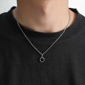 Minimalist silver chain necklace with black round pendant worn on a model in black t-shirt