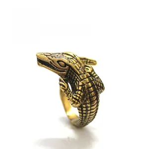 Macro view showing intricate scale textures and vintage gold finish of the crocodile ring