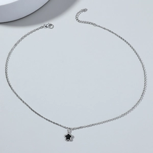 Detail of silver chain necklace featuring black star pendant and secure lobster clasp