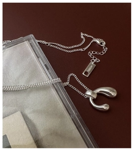Detailed view of S925 sterling silver U-shaped pendant and AG925 hallmark tag