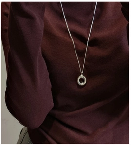 Minimalist S925 sterling silver circle necklace pendant on a dark red turtleneck sweater