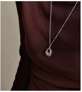Collier minimaliste en argent S925 goutte d'eau sur un pull à col roulé bordeaux foncé