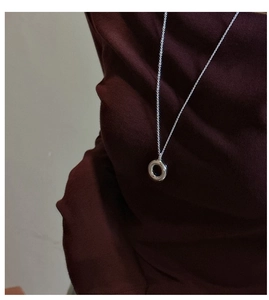 Polished S925 sterling silver hollow circle pendant necklace worn on a dark brown shirt