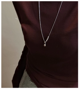 Close-up of a minimalist 925 silver slider necklace with beads and a round sphere pendant