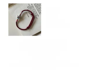 Détail de breloque chat porte-bonheur en argent S925 sur bracelet rouge ajustable