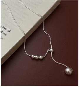 Detail of 925 sterling silver snake chain with frosted beads on vintage book pages