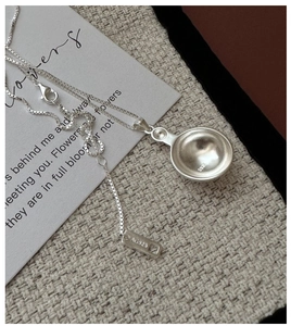 Detail of S925 sterling silver round pendant with AG925 stamp on minimalist box chain