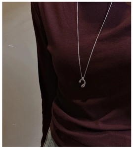 Long S925 sterling silver water drop necklace styled on a burgundy turtleneck sweater
