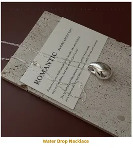 Détail d'un pendentif goutte d'eau en argent minimaliste avec une finition miroir polie