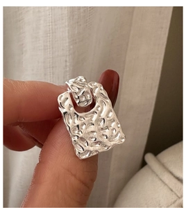 Detail of S925 silver earrings with hammered texture and minimalist geometric design