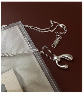 Macro detail of S925 sterling silver waterdrop pendant with AG925 hallmark on a thin chain