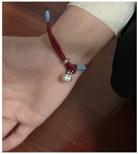 Detail view of S925 silver persimmon charm on handcrafted red braided cord bracelet